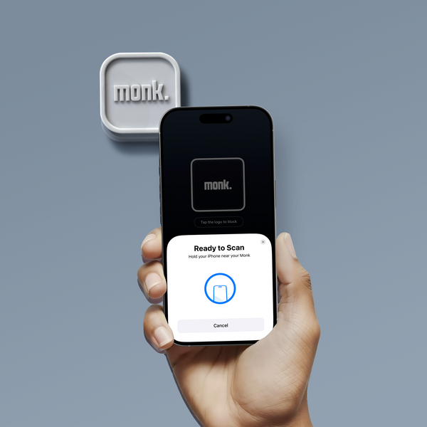 Disco NFC Monk junto a un iPhone mostrando la pantalla de escaneo para bloquear apps